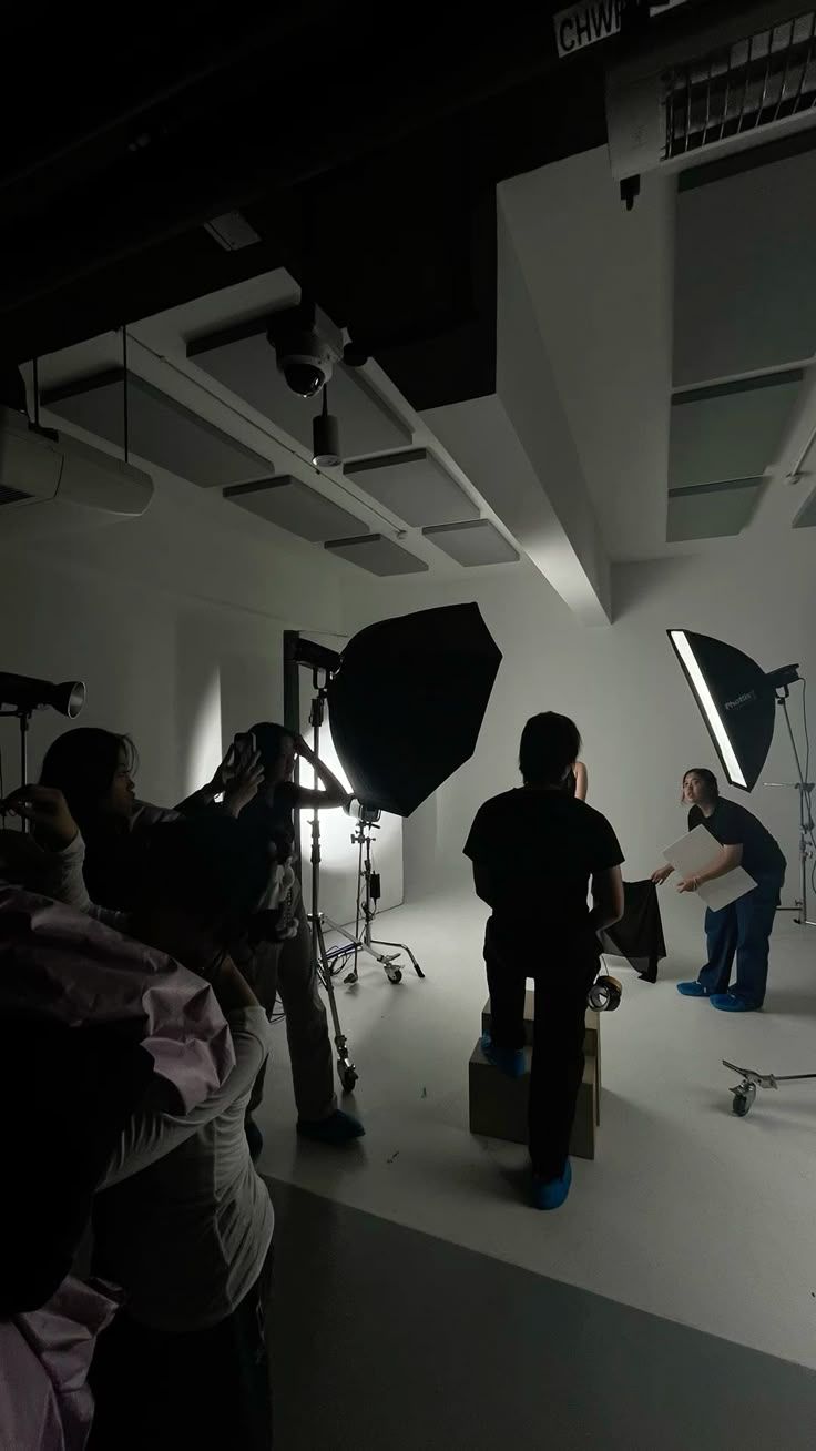 A film crew placing softbox lights in a white studio.
